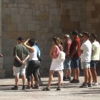 Un grupo de turistas atiende a la guía de la ciudad.