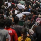 Refugiados palestinos recogen alimentos en Gaza.