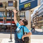 Una joven intenta darse sombra con la mano en una de las jornadas más calurosas.