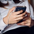 Una adolescente escucha música desde su móvil.