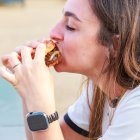 Una mujer disfruta de su hamburguesa en The Champions Burguer en León.