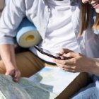 Una mujer consulta el móvil en compañía de su pareja en un viaje.