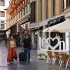 Imagen de dos turistas en la calle Ancha de León.