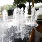 Una mujer sentada ante una fuente en León.
