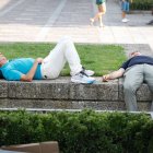 Dos personas descansan a la sombra en la plaza de San Marcelo, ayer en León.