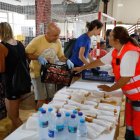 Voluntarios preparan comida y bebida para los realojados en el polideportivo de La Bañeza.