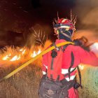 Una agente de la Unidad Militar de Emergencias (UME) trabaja en las labores de extinción del incendio, a 12 de agosto de 2025, en Tres Cantos, Madrid (España).