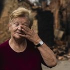 Una vecina de Castrocalbón, junto a una vivienda que ha sido destruida por los incendios.
