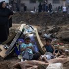 Niños desplazados palestinos entre las ruinas de su asentamiento tras el ataque israelí.