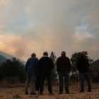 Varios vecinos contemplan el fuego del incendio de Boca de Huérgano.