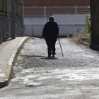 Una persona mayor camina sola por las calles de un pueblo de León.