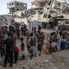 Un grupo de niños hace cola para coger agua potable en Gaza.