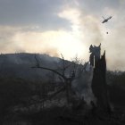 Un helicóptero sobrevuela la zona quemada en el incendio de Molinaseca declarado el pasado domingo.