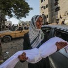  Una mujer palestina lleva el cuerpo de su hijos.