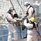 Equipos de rescate ayudan a un migrantes en el puerto de Puerto de Arguineguín.