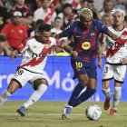 Lamine Yamal pugna con el rayista Álvaro García por el control del balón.