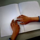 Una niña lee un libro con el lenguaje braille .