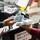Un usuario confirma con su teléfono su tarjeta de Buscyl en un autobús leonés.