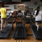 Dos personas hacen ejercicio en un gimnasio.