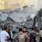 Un grupo de palestinos observa los escombros tras uno de los ataques lanzados por Israel ayer en Gaza.