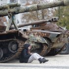 Una niña ucraniana descansa junto a un grupo de tanques.