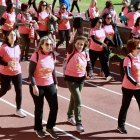 Una mujer hace el signo de la victoria al finalizar la exitosa Carrera de la Mujer en León.