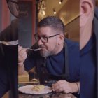 Hombre probando una tortilla de patatas cremosa en un restaurante con ambiente cálido