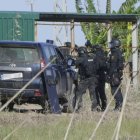 Agentes de policía desplegados frente a la nave del tiroteo.