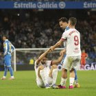 El delantero Rubén Sobrino, en el suelo, es ayudado por un compañero a levantarse.