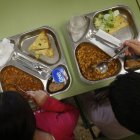 Dos niños, con el menú de un comedor escolar.