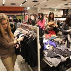 Una joven busca una prenda en un comercio.