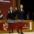 Alba Yadira Machaca (d) e Italy Andrea Blanco cantan el número agraciado con el premio gordo del Sorteo de la Lotería de Navidad.