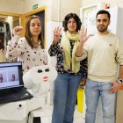 Virginia Riego junto a dos compañeros del Grupo de Robótica de la Universidad de León realizan la señal de socorro.