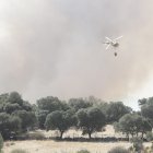 Un helicóptero sofoca un incendio forestal en un bosque de la Comunidad en Maíllos.