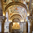 El interior del Panteón Real sorprende por la riqueza decorativa de sus columnas y la narrativa visual continua de sus frescos, que cubren bóvedas y muros con escenas bíblicas de gran fuerza simbólica y colorida vitalidad medieval.
