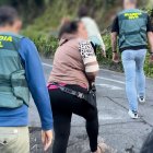 Dos agentes de la Guardia Civil con personas detenidas