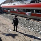 Un agente de la Guardia Civil ante el tren Iryio que circulaba en sentido Madrid siniestrado en el accidente ferroviario ocurrido el pasado domingo.