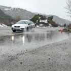 Un coche pasa sobre uno de los grandes charcos en el desvío por La Recuelga.