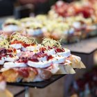 Tapas creativas y coloridas listas para ser servidas en un local tradicional, donde la mezcla de ingredientes eleva el tapeo a otro nivel.