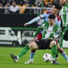 Marc Roca, del Betis, pugna con Inbeom Hwang, del Feyenoord.