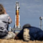Fotógrafos de prensa toman imágenes del Space Launch System (SLS) con la cápsula de Orion.