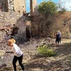 Vecinos ayudando a limpiar la zona afectada por los incendios.  Montaña de ramas en los alrededores del monasterio.