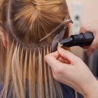 Un profesional realiza unas extensiones de pelo a una mujer.