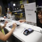Una mujer entrega la documentación para ejercer el voto por correo en una imagen de archivo.