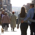Varias personas pasean por la calle.