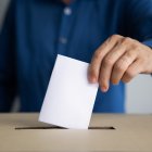 Una persona introduce su voto en la urna