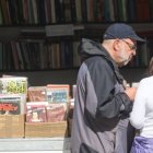 Visitantes revisan libros antiguos y descatalogados en una de las casetas de la Feria del Libro Antiguo y de Ocasión de Ponferrada