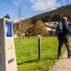 Un peregrino avanza por el Camino de Santiago siguiendo la señal jacobea, símbolo de una ruta que vive una creciente presión por el aumento de visitantes