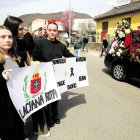 Varias jóvenes sostienen pancartas de duelo en el funeral de los mineros.