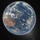 Imagen tomada de la cuenta oficial en X de la @NASA que muestra una fotografía de la Tierra tomada por la tripulación de Artemis II, captada con una velocidad de obturación lenta, mostrando remolinos de nubes blancas, una gran masa terrestre de color marrón que corresponde a África, dos auroras boreales en la parte superior derecha e inferior izquierda, y la luz zodiacal (abajo a la derecha). E.